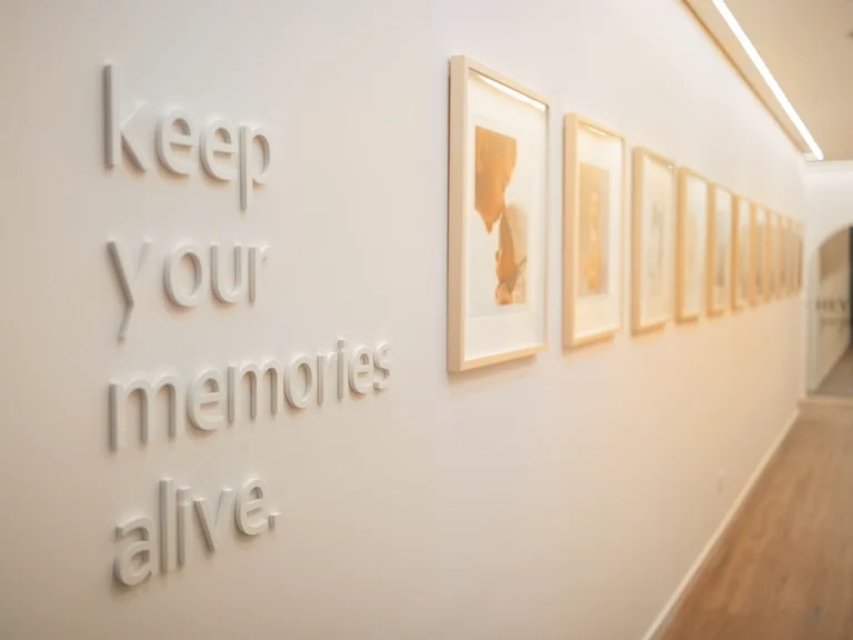 Detalhe de parede com frase inspiracional e quadros minimalistas num estúdio de fotografia de família no Porto.