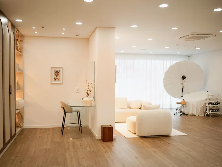 Sala ampla de estúdio fotográfico newborn no Porto com iluminação profissional e área de descanso.